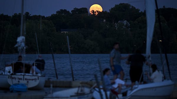 Giant August super blue moon amazes as it rises over Lake Harriet