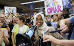 Supporters stand with Omar at airport rally and town hall