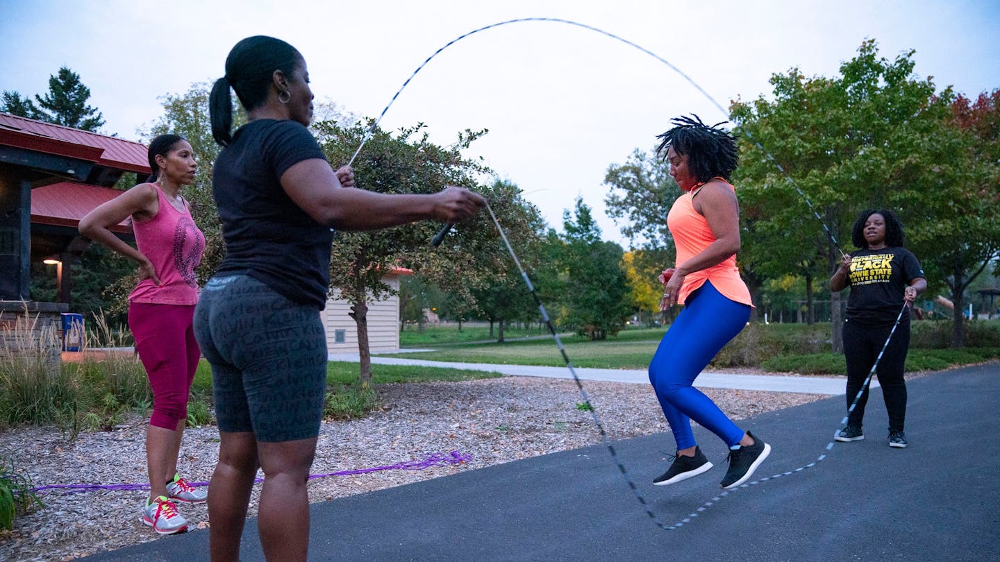 Athletic black girl exercising with skipping rope at park Stock