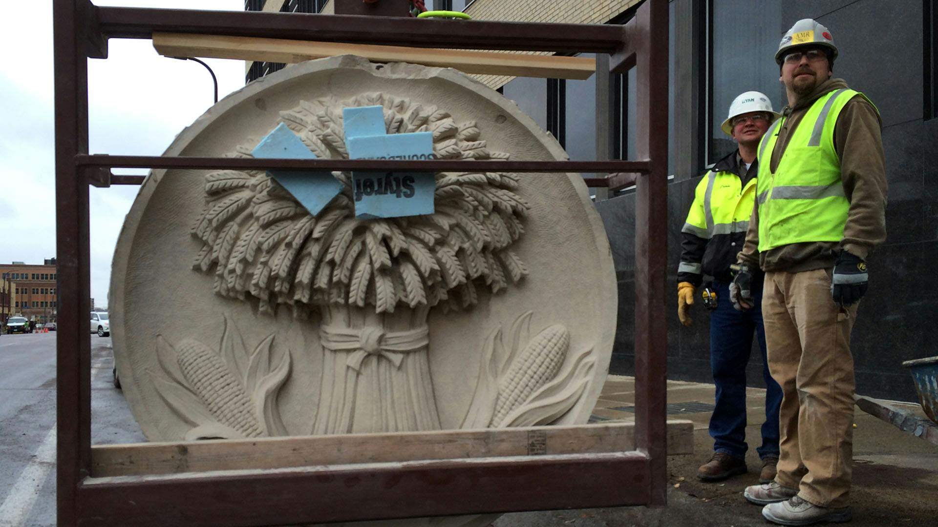 Crews from Ryan Companies worked to remove six historic medallions from the Star Tribune building.