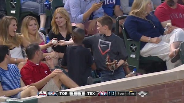 Young boy at baseball game pretends to give foul ball to woman