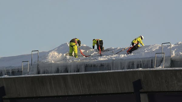 Workers clear snow off Dome roof