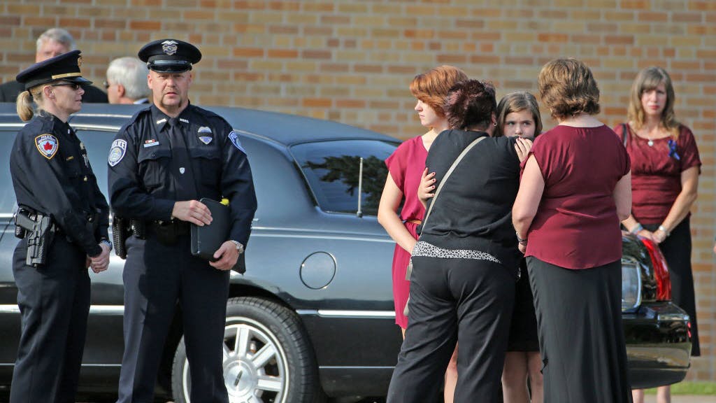 Officer Scott Patrick's wife and daughters arrived at St. Stephen's Lutheran Church in West St. Paul for his funeral Wednesday morning.