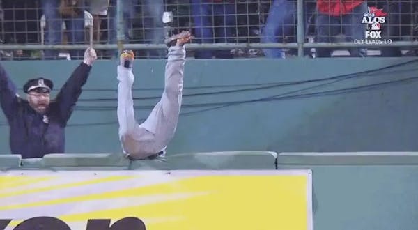 Torii Hunter goes over the wall as cop cheers