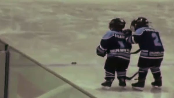 Little hockey player gets help from a friend