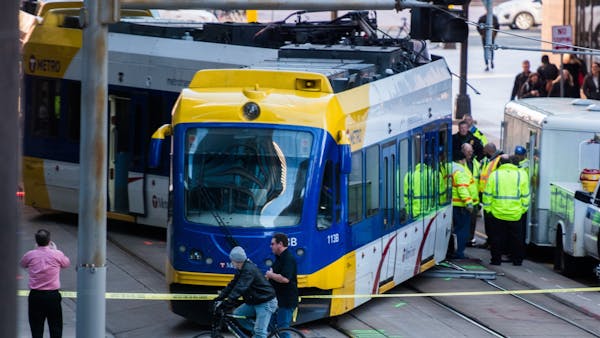 Derailed light-rail cars are pulled back on track