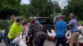 Volunteers help unload sandbags in Windom next to Perkins Creek