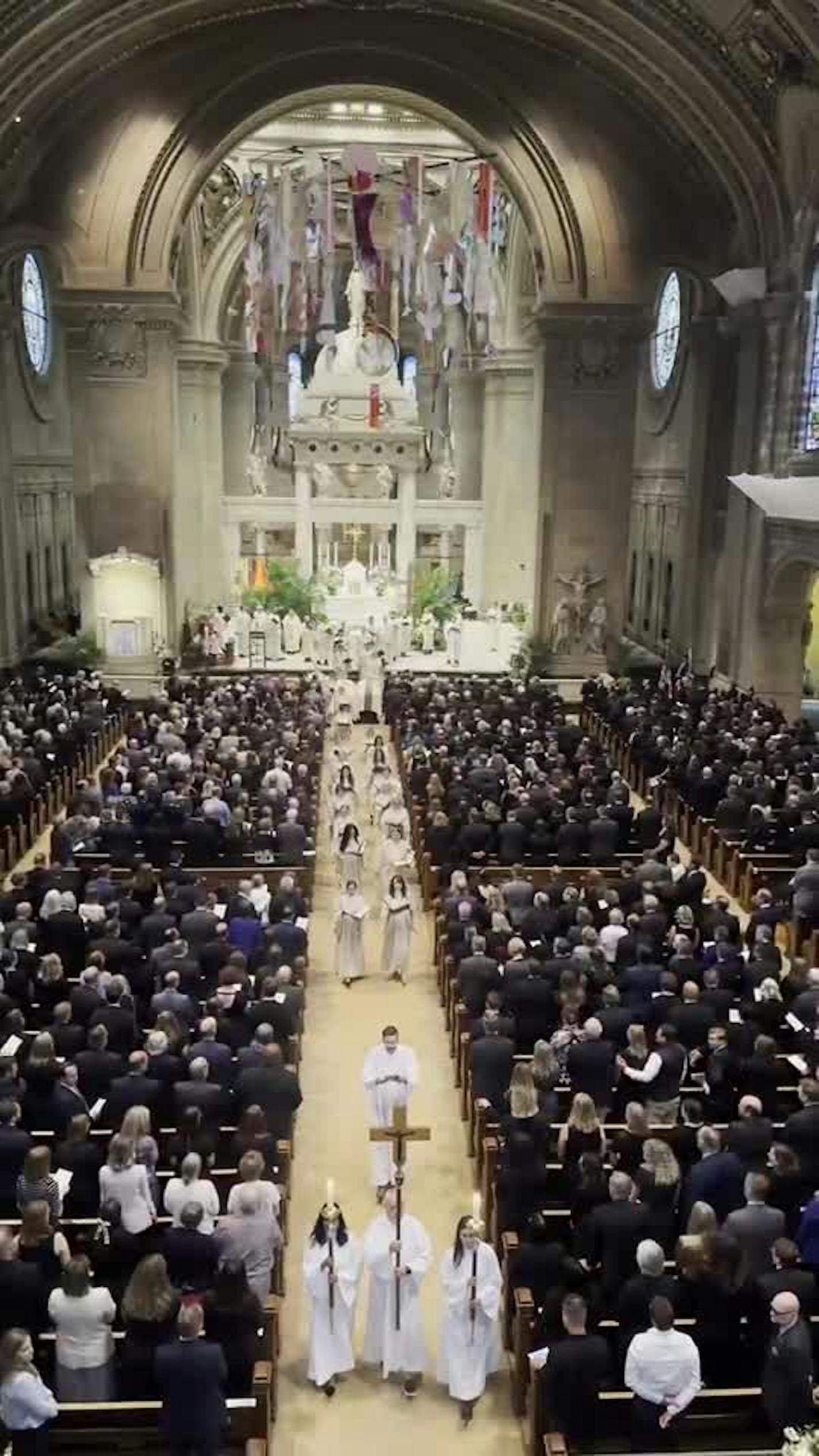 The choir exits the stage at the front of the Basilica Saturday