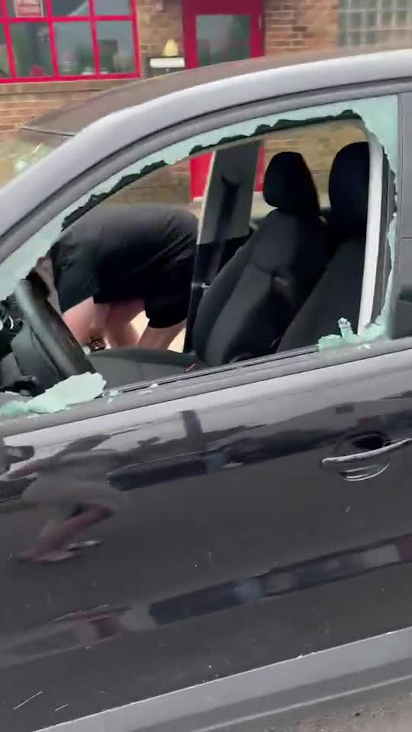 People clean up after their vehicles were vandalized sometime from Sunday night to Monday morning.